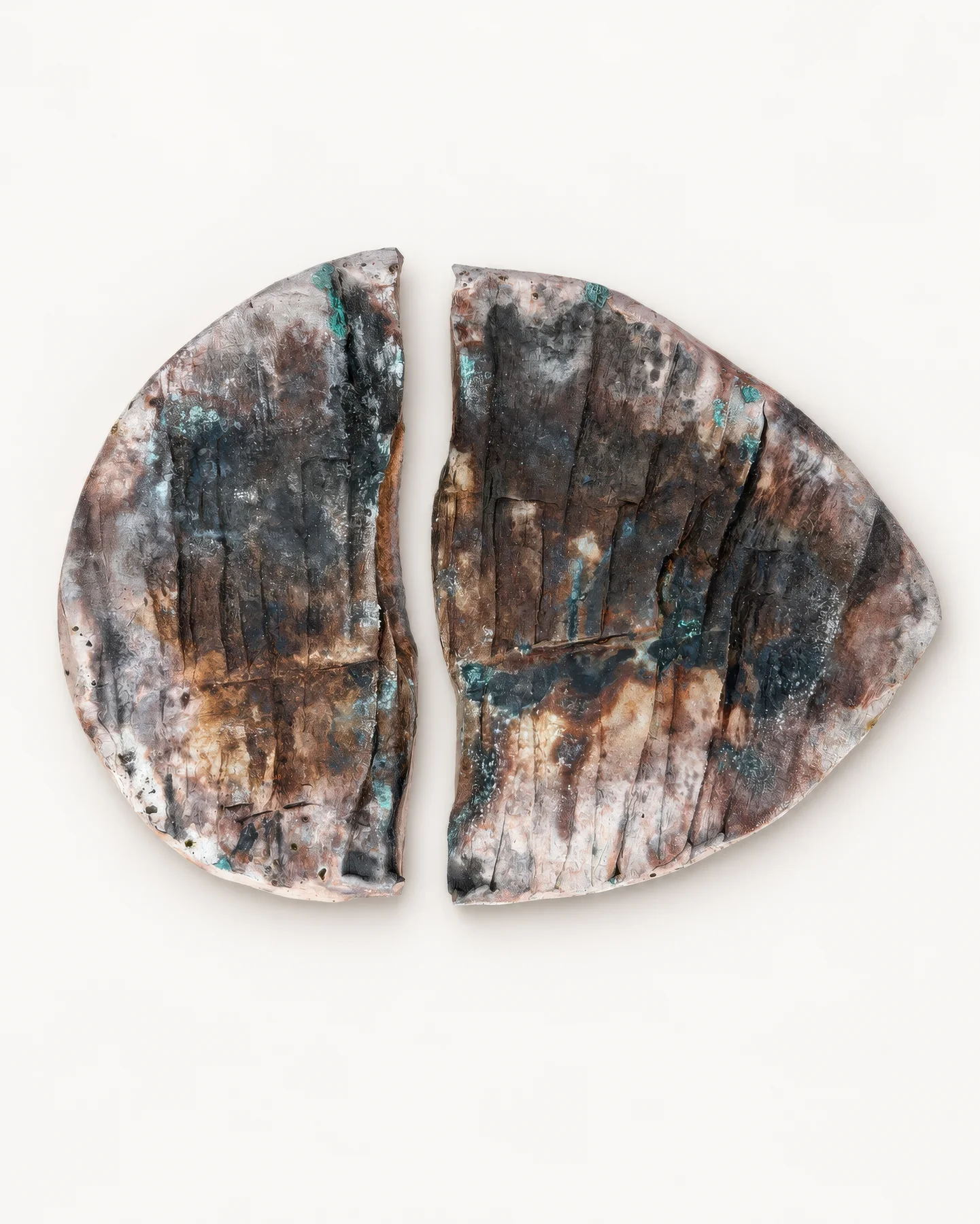 Saggar Piece 2: a ceramic piece broken in two, with teal glaze marks.